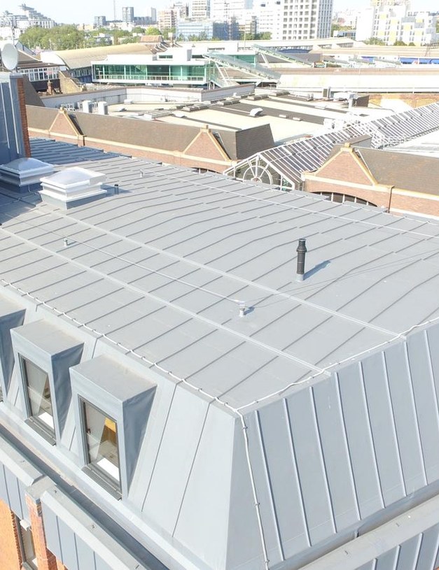 Completed commercial roof with grey standing seam detailing